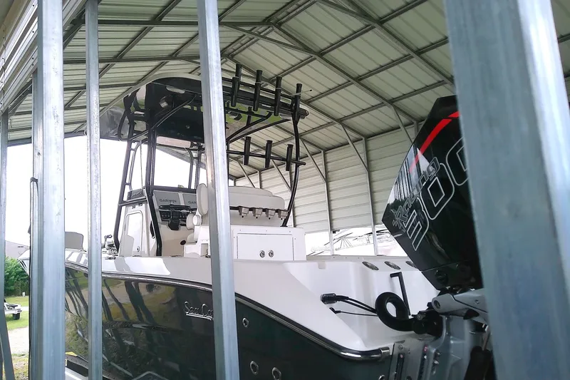 Slide: The Image of A 2022 Sea Cat 260 is in a covered area. The cockpit and outboard motor are visible. - 25