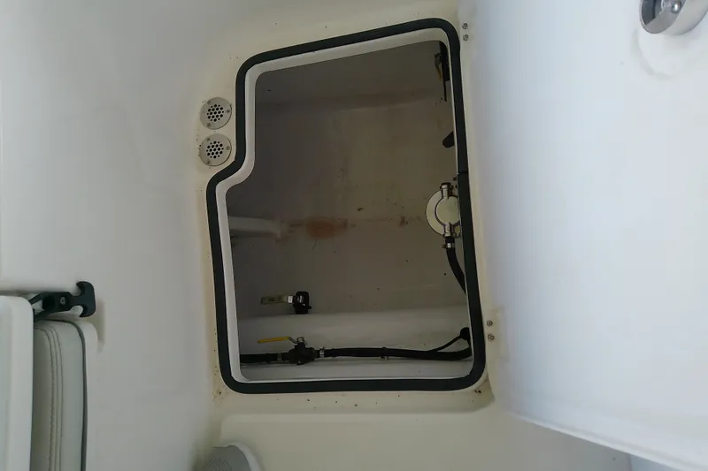 Slide: The Image of Storage compartment of a 2022 Sea Cat 260 boat, featuring interior fittings and hoses. - 76