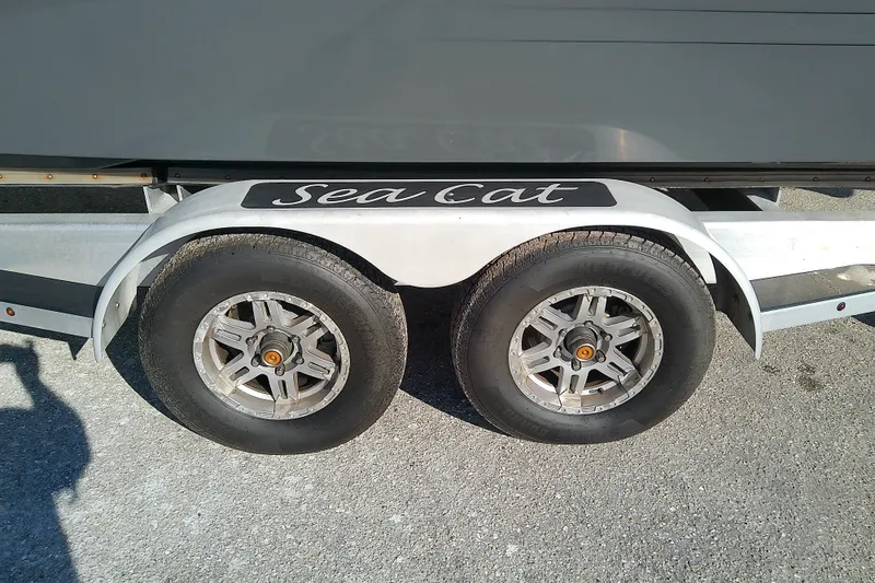 Slide: The Image of Trailer with dual wheels for 2022 Sea Cat 260 boat, parked on asphalt. - 20