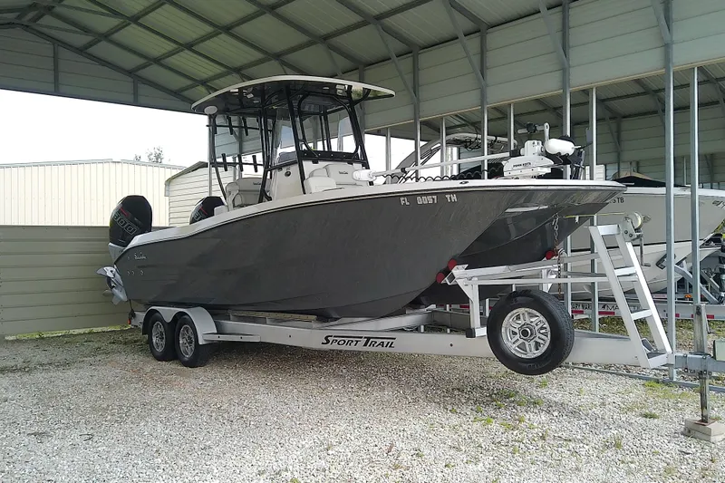 Slide: The Image of 2022 Sea Cat 260 boat on trailer under shelter, featuring dual engines. - 0