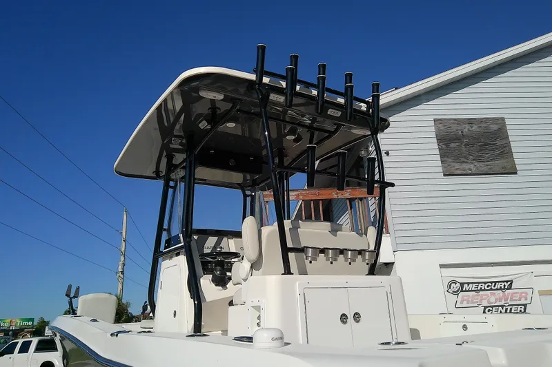Slide: The Image of 2022 Sea Cat 260 boat with T-top and rod holders, parked near a building. - 8