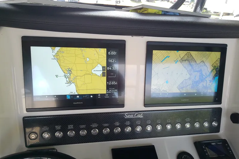 Slide: The Image of Dashboard of a 2022 Sea Cat 260 boat with dual Garmin navigation screens. - 65