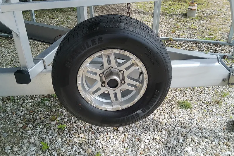 Slide: The Image of Trailer wheel of a 2022 Sea Cat 260 on gravel surface. - 29