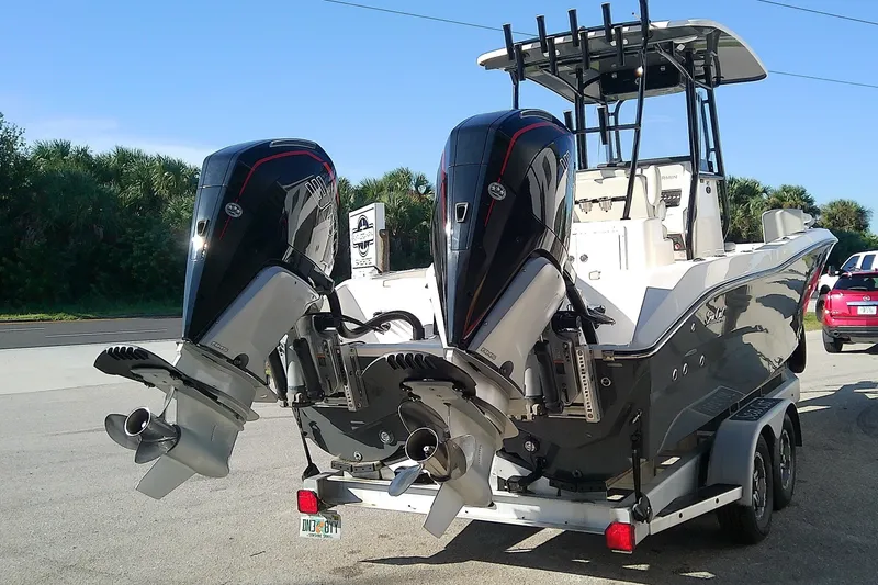 Slide: The Image of 2022 Sea Cat 260 boat on trailer with dual outboard motors, parked outdoors. - 4