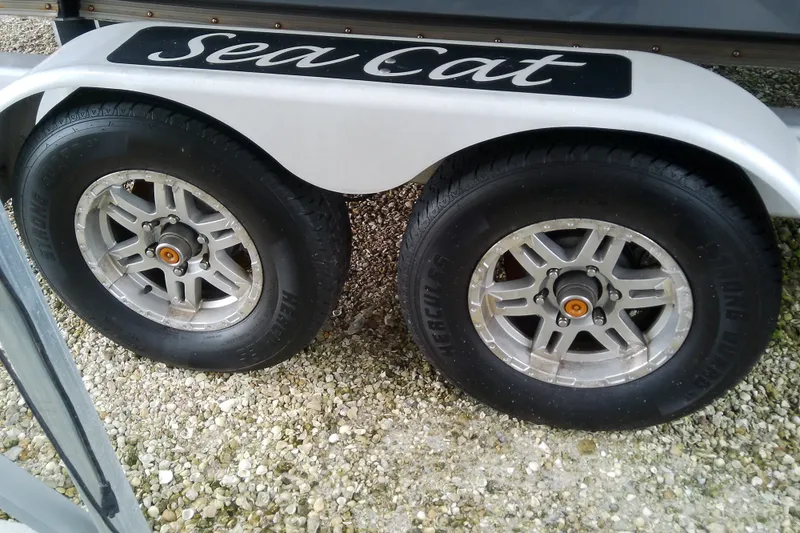 Slide: The Image of Trailer wheels of a 2022 Sea Cat 260 on gravel surface. - 28