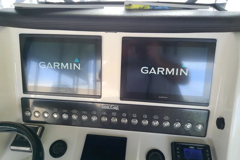 Slide: The Image of Dashboard of 2022 Sea Cat 260 with dual Garmin displays and control panel. - 63