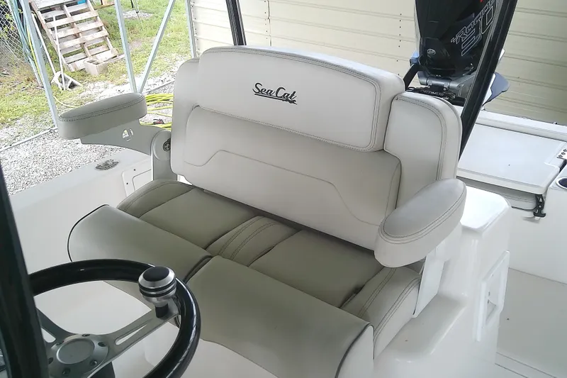 Slide: The Image of A 2022 Sea Cat 260 featuring a cushioned double seat and a steering wheel. - 44