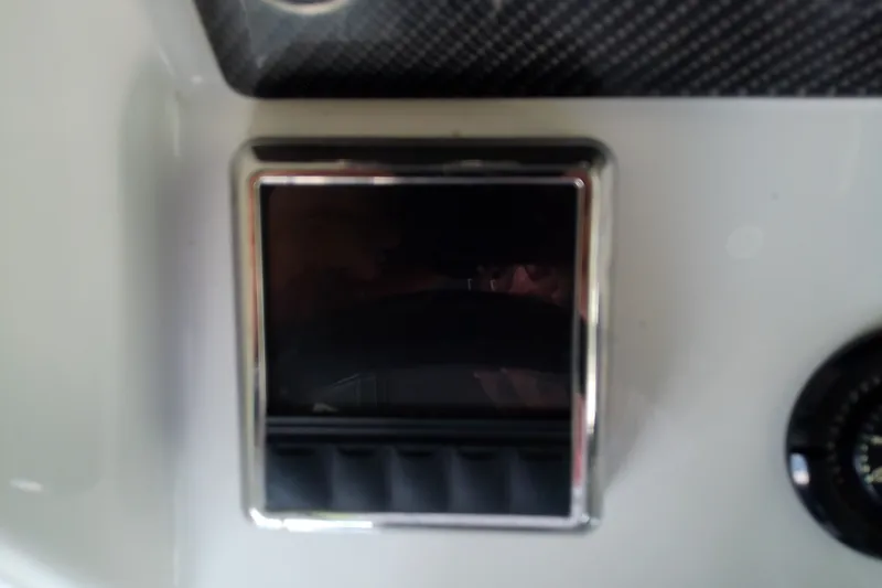 Slide: The Image of Dashboard detail of a 2022 Sea Cat 260 boat, featuring a control panel and compass. - 70
