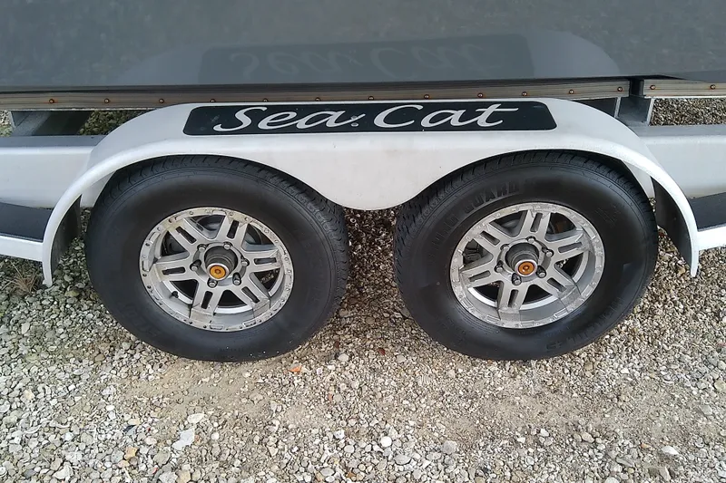 Slide: The Image of Trailer wheels of a 2022 Sea Cat 260 on gravel surface. - 27