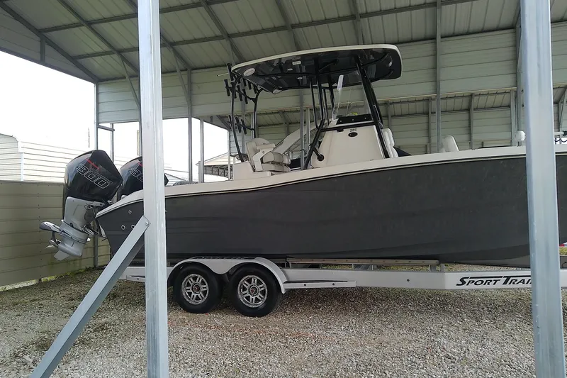 Slide: The Image of A 2022 Sea Cat 260 boat sits on a trailer in a covered area. - 1