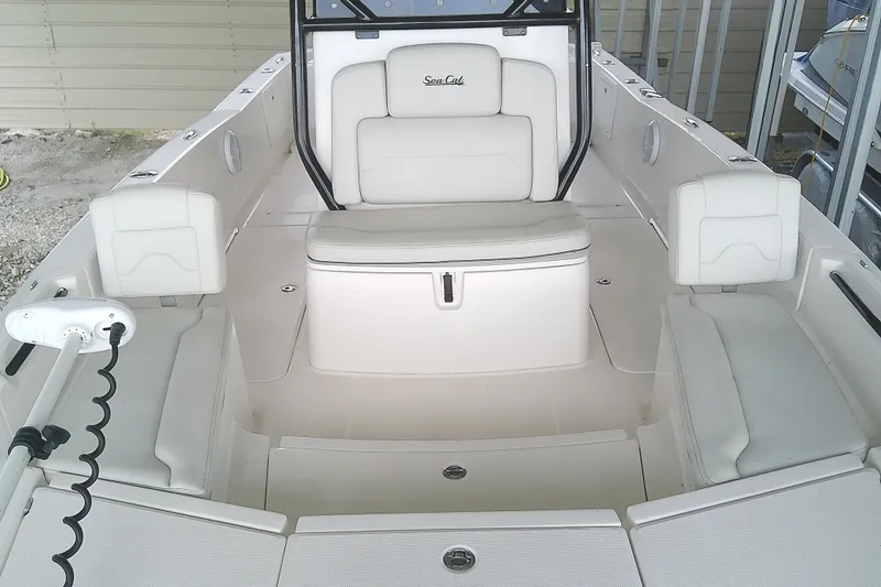 Slide: The Image of The image shows the cockpit of a 2022 Sea Cat 260 boat with white upholstery. - 33