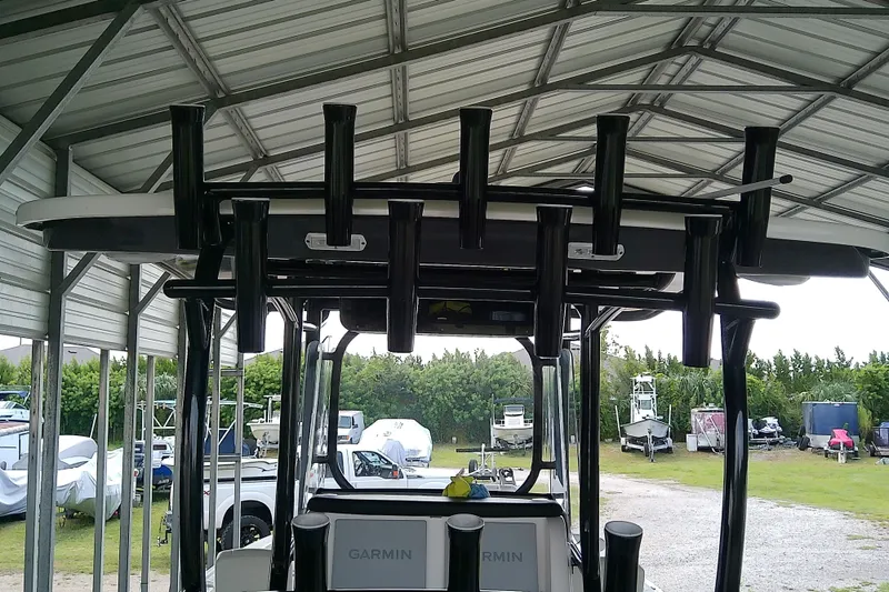 Slide: The Image of 2022 Sea Cat 260 boat under metal shelter, featuring multiple rod holders and Garmin equipment. - 54