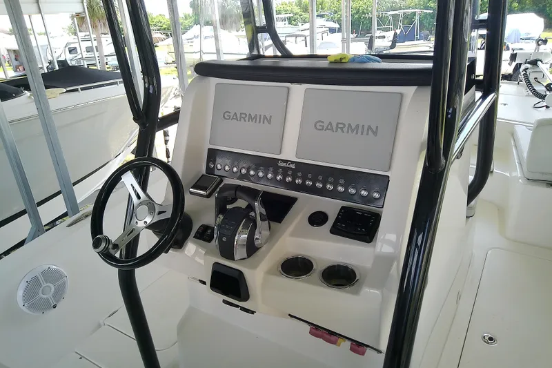 Slide: The Image of 2022 Sea Cat 260 boat dashboard with Garmin displays and steering wheel. - 62