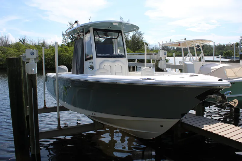 The Image of 2019 Sea Hunt Gamefish 25 boat docked on a lift by the water. - 0