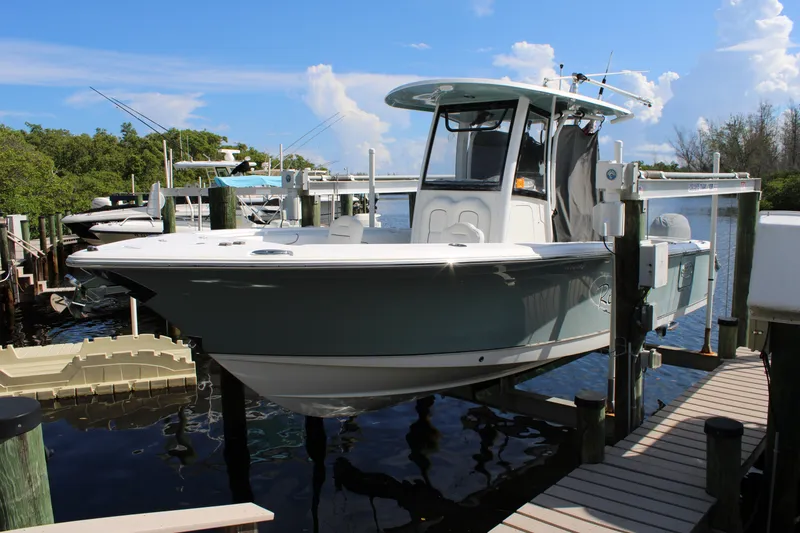 Slide: The Image of 2019 Sea Hunt Gamefish 25 boat docked, featuring sleek design and modern amenities. - 2