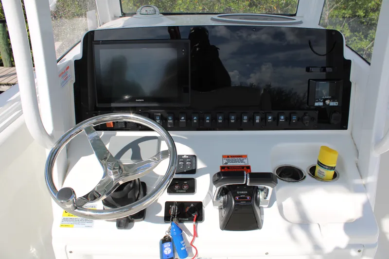 Slide: The Image of 2019 Sea Hunt Gamefish 25 helm with steering wheel, Garmin display, and Yamaha controls. - 14