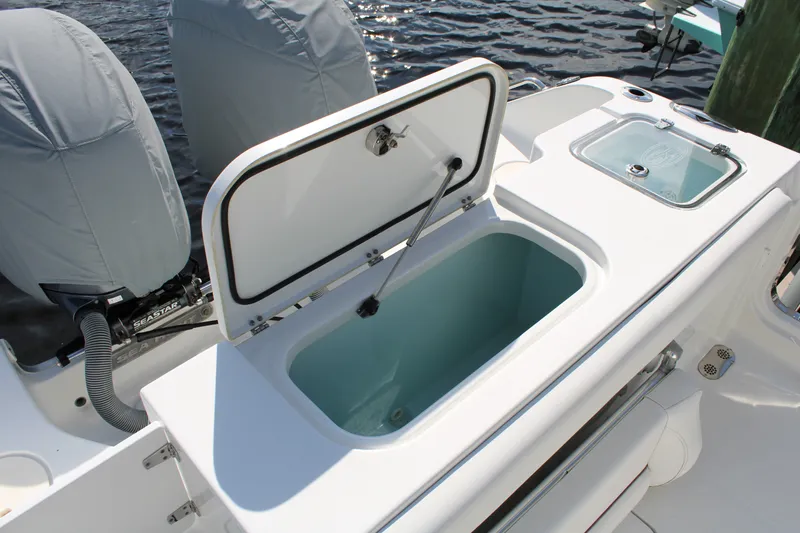 Slide: The Image of 2019 Sea Hunt Gamefish 25 boat with open storage compartment and covered engines. - 29
