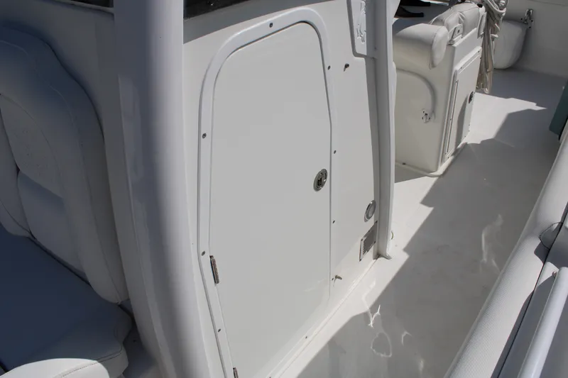 Slide: The Image of 2019 Sea Hunt Gamefish 25 interior with white seating and storage compartments. - 38