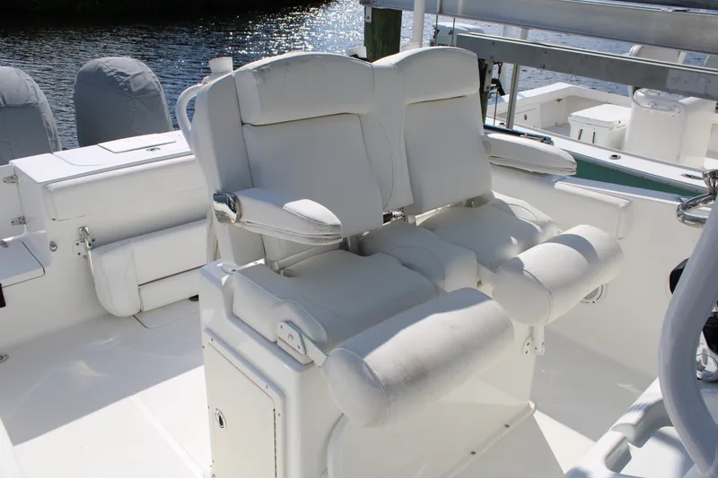 Slide: The Image of 2019 Sea Hunt Gamefish 25 boat with white cushioned seating and helm station. - 26