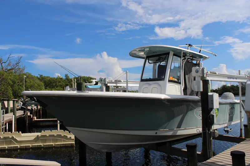 Slide: The Image of 2019 Sea Hunt Gamefish 25 boat docked under a clear blue sky. - 1