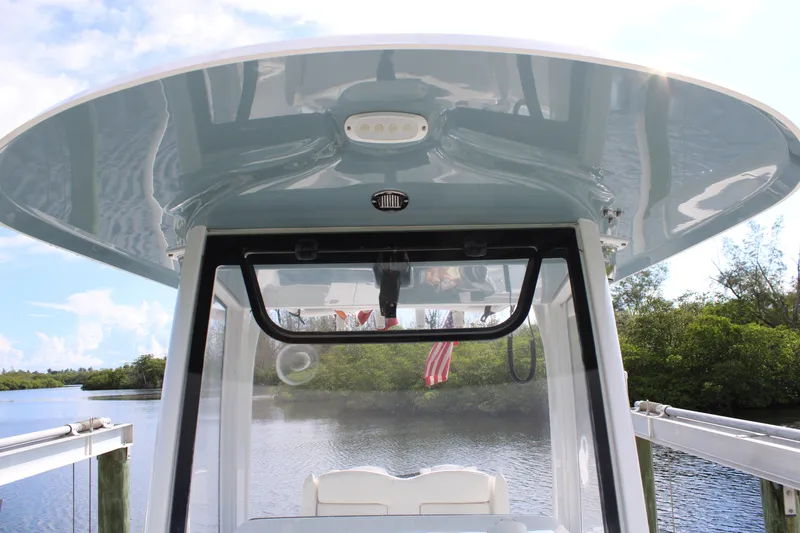 Slide: The Image of 2019 Sea Hunt Gamefish 25 boat with T-top, docked by a scenic river. - 22