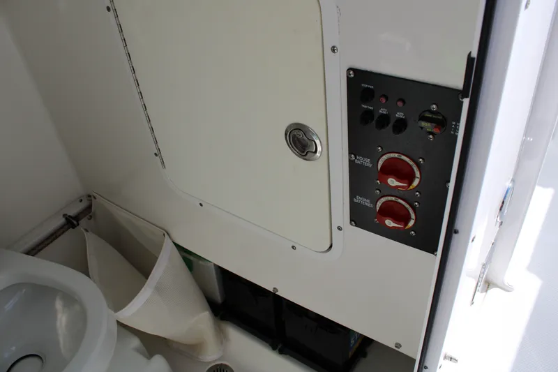 Slide: The Image of 2019 Sea Hunt Gamefish 25 boat interior showing battery controls and storage compartment. - 40