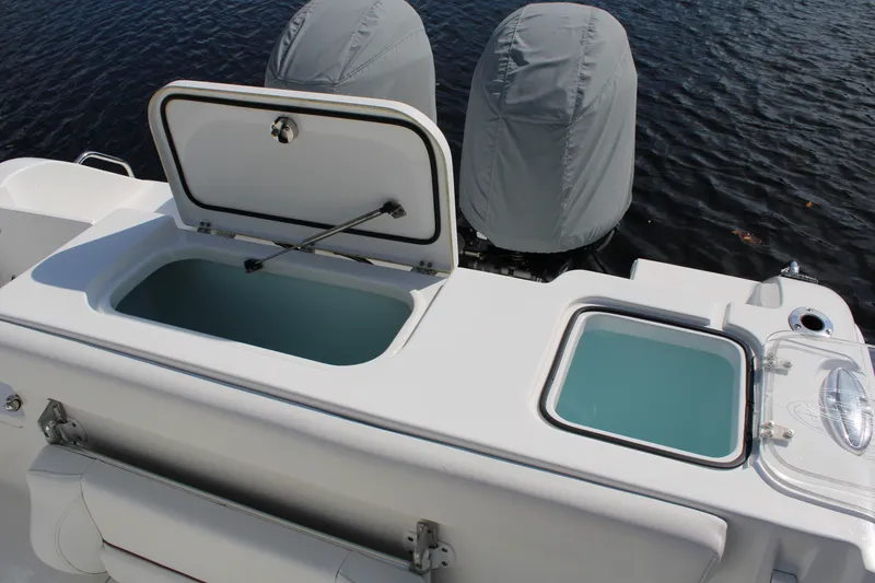 Slide: The Image of 2019 Sea Hunt Gamefish 25 boat with open storage compartments and covered engines. - 30