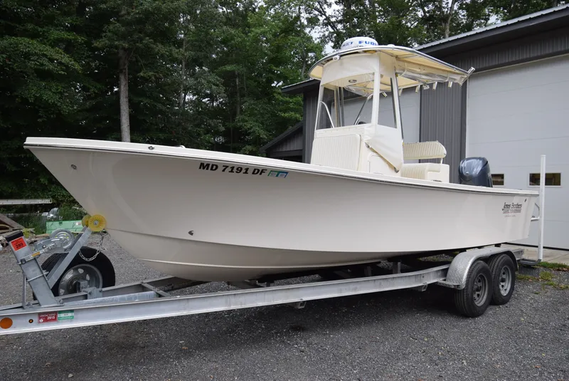 The Image of A 2024 Jones Brothers Cape Fisherman 23 on a trailer, parked in front of a building. - 0