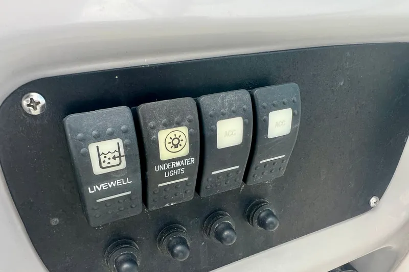Slide: The Image of Control panel of 2024 Robalo R207 Dual Console with livewell and underwater lights switches. - 12