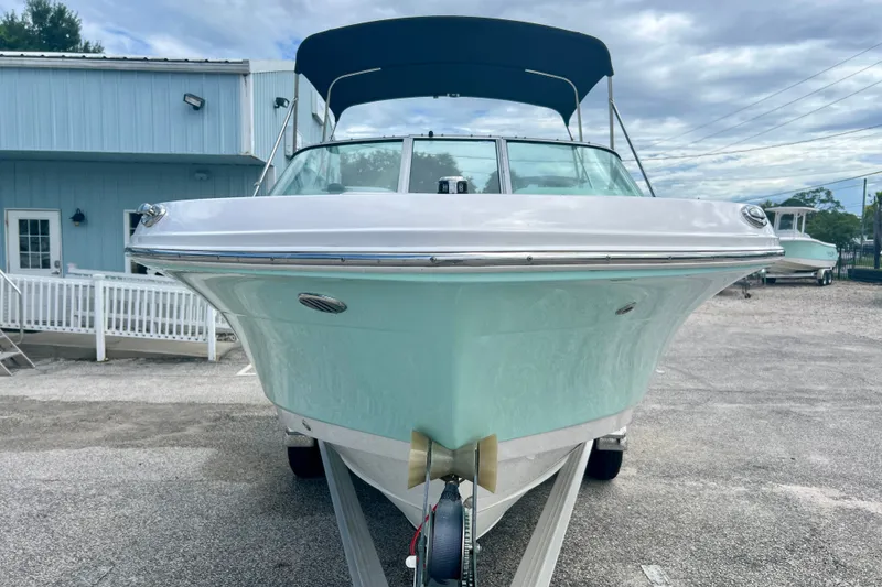 Slide: The Image of 2024 Robalo R207 Dual Console boat with blue hull, parked outdoors. - 3