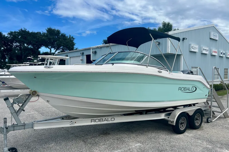Slide: The Image of 2024 Robalo R207 Dual Console boat on trailer, parked outside dealership. - 4