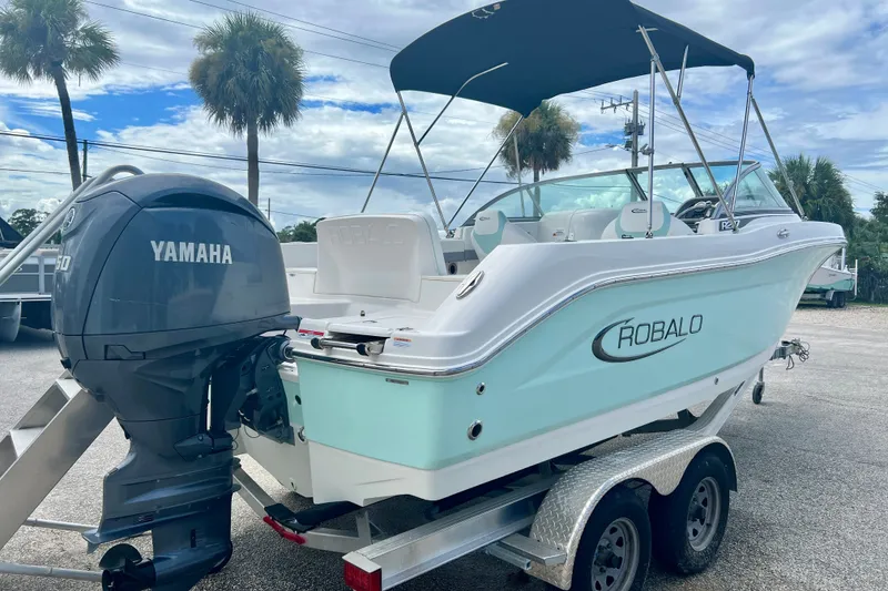 Slide: The Image of 2024 Robalo R207 Dual Console boat with Yamaha engine on trailer, parked outdoors. - 7