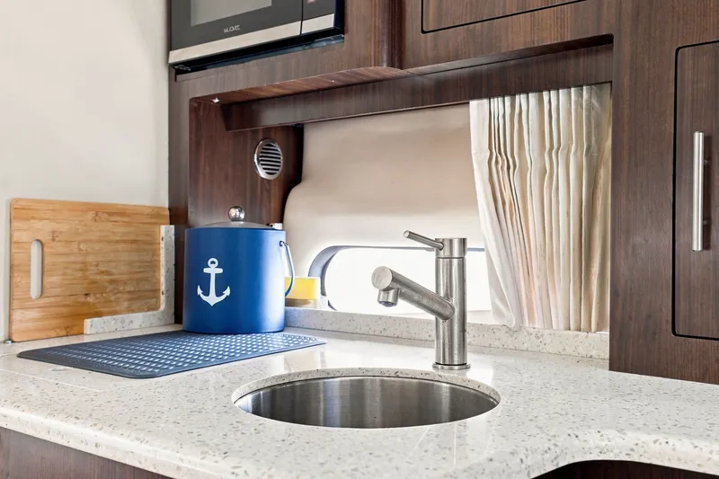 Slide: The Image of 2018 Regal 33 XO yacht kitchen with modern sink, wooden cabinetry, and nautical decor. - 67