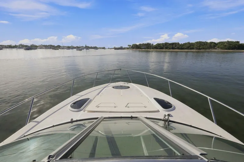 Slide: The Image of Bow view of 2018 Regal 33 XO yacht cruising on a calm river under blue skies. - 30
