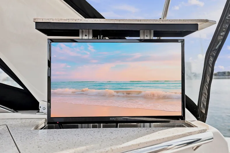 Slide: The Image of Flat-screen TV on 2018 Regal 33 XO yacht, displaying serene beach scene. - 49