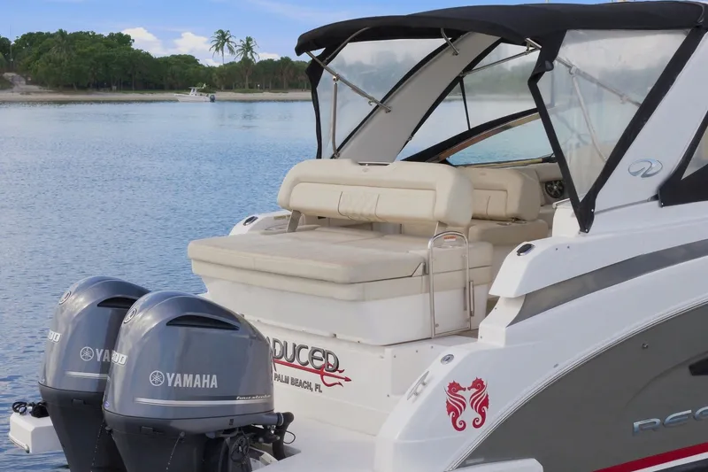 Slide: The Image of 2018 Regal 33 XO boat with Yamaha engines, docked on a serene lake. - 24