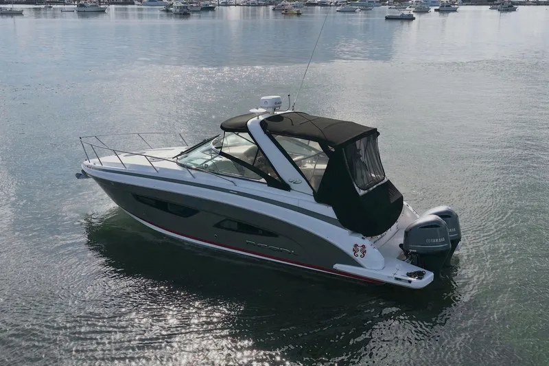 Slide: The Image of 2018 Regal 33 XO boat on calm water, featuring sleek design and Yamaha engines. - 10