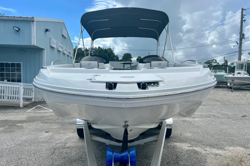Slide: The Image of 2024 Hurricane Sundeck Sport 218 OB boat with canopy, parked on a trailer. - 3