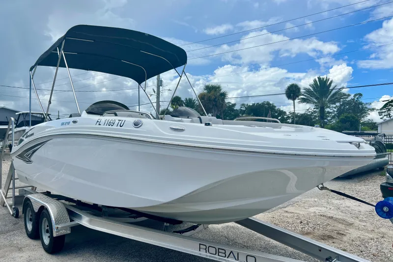 Slide: The Image of 2024 Hurricane Sundeck Sport 218 OB boat on trailer, under blue sky. - 2