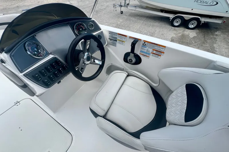 Slide: The Image of 2024 Hurricane Sundeck Sport 218 OB boat cockpit with steering wheel and comfortable seating. - 12