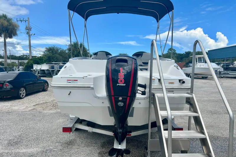 Slide: The Image of 2024 Hurricane Sundeck Sport 218 OB boat with Mercury 150 engine, parked outdoors. - 7