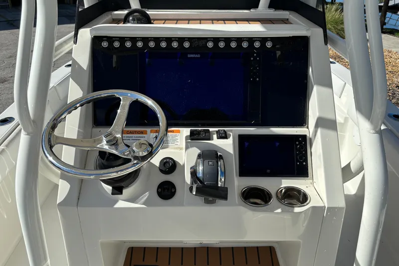 Slide: The Image of 2022 Ranger 2660 Bay boat dashboard with steering wheel and navigation controls. - 5