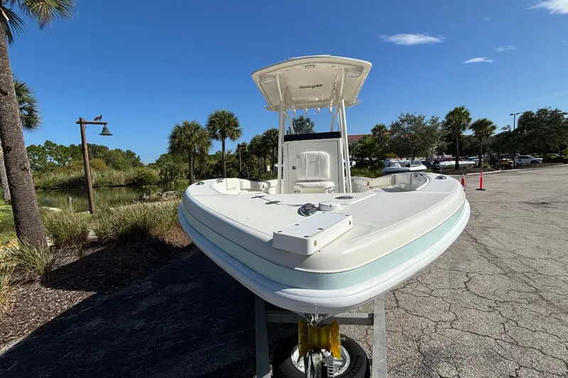Slide: The Image of 2022 Ranger 2660 Bay boat on trailer, surrounded by palm trees and clear blue sky. - 2