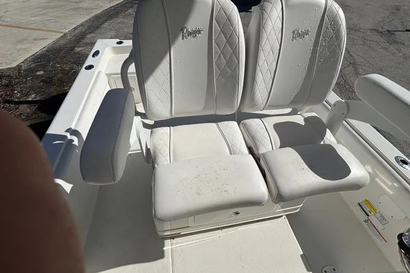 Slide: The Image of White leather seating on a 2022 Ranger 2660 Bay boat, featuring armrests and diamond stitching. - 10