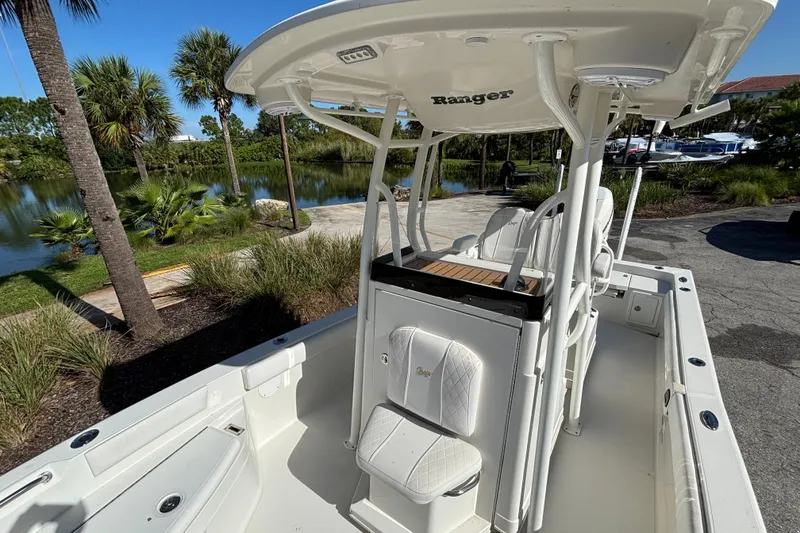 Slide: The Image of 2022 Ranger 2660 Bay boat with seating, parked near a scenic lake. - 7