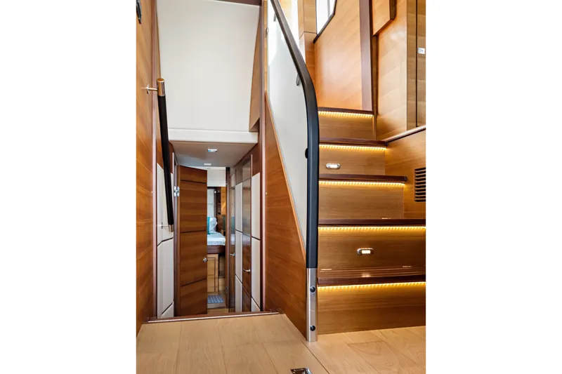 Slide: The Image of Interior of 2024 North Pacific 450 Pilothouse with wooden stairs and modern lighting. - 9