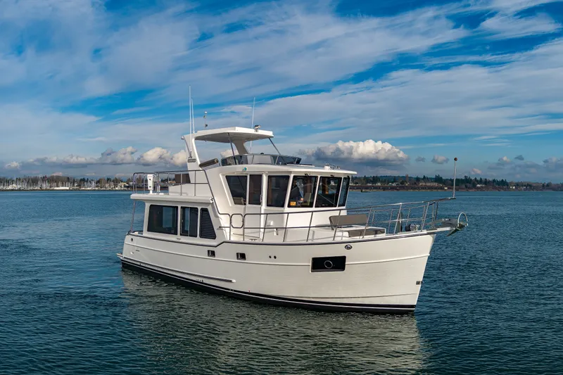 Slide: The Image of 2024 North Pacific 450 Pilothouse yacht cruising on a calm sea under a blue sky. - 1