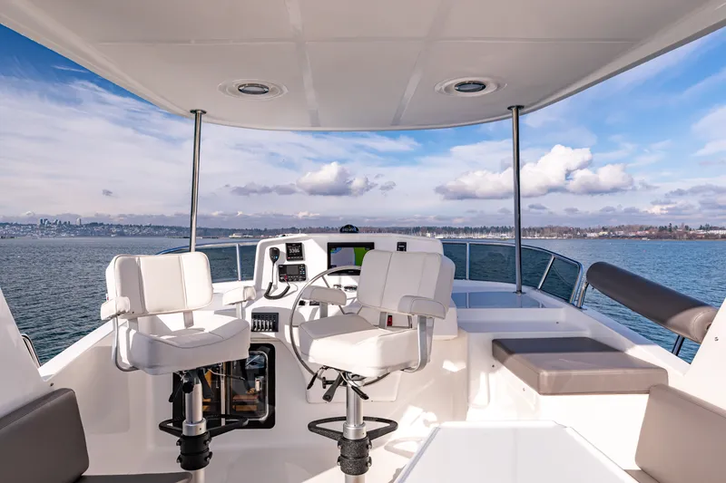 Slide: The Image of 2024 North Pacific 450 Pilothouse helm with ocean view and modern seating. - 21