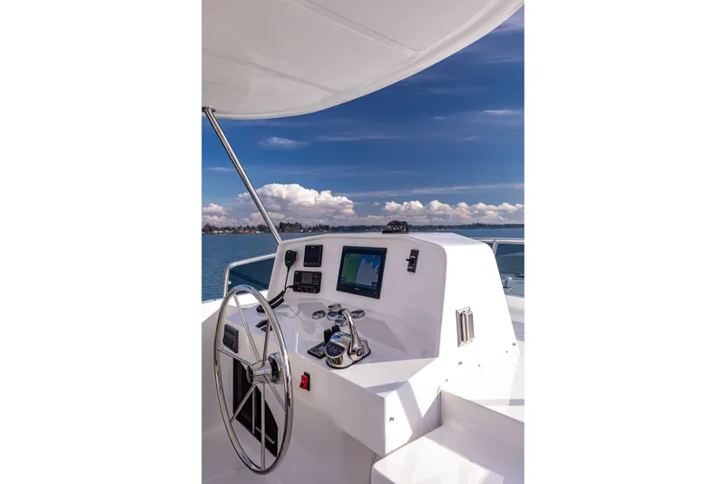 Slide: The Image of 2024 North Pacific 450 Pilothouse helm with navigation equipment and ocean view. - 23
