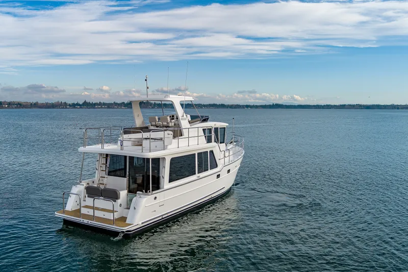 Slide: The Image of 2024 North Pacific 450 Pilothouse yacht cruising on open water under a clear sky. - 2